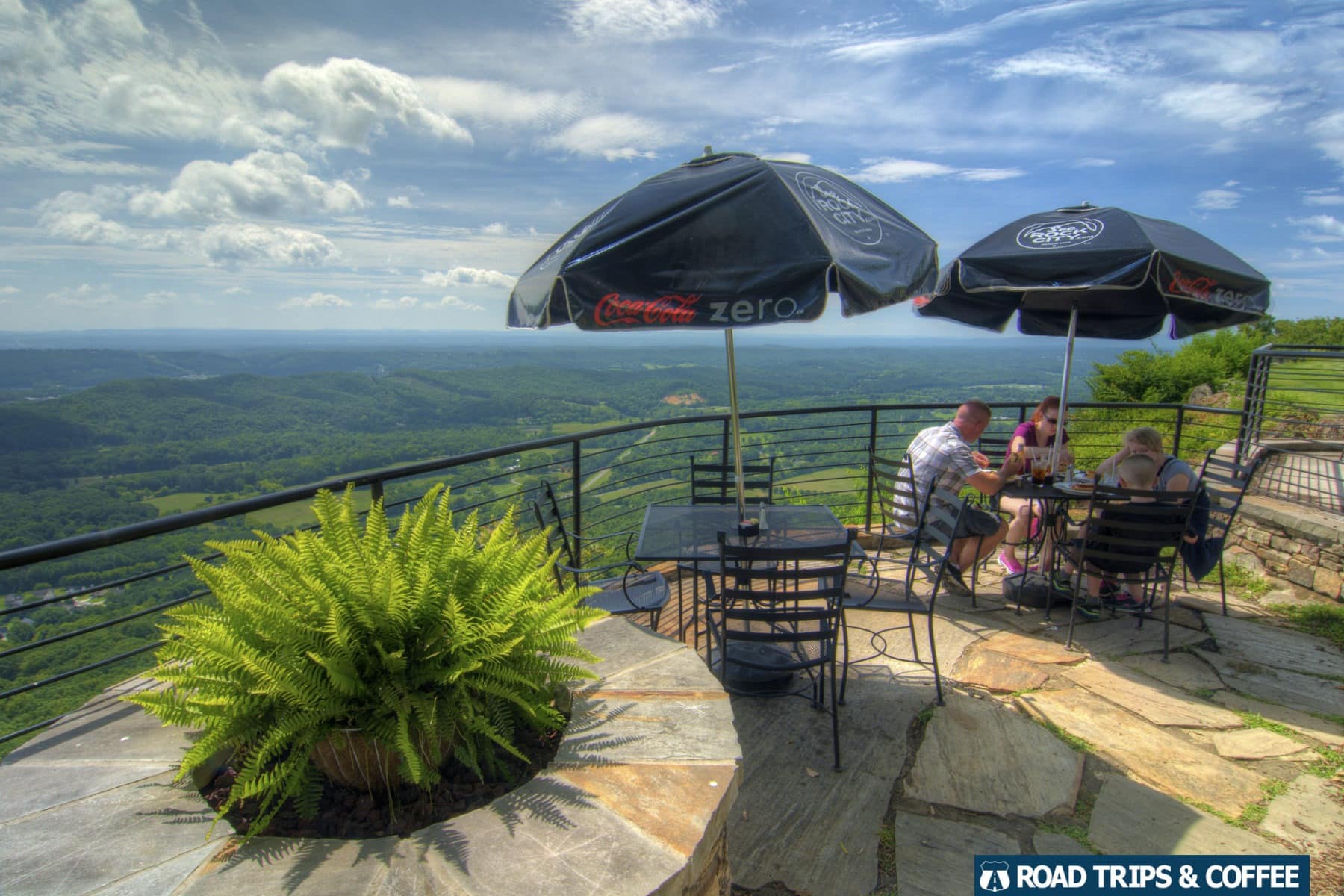 A couple of tables on a stone patio with a stunning view of the local landscape at Rock City in Lookout Mountain, Tennessee